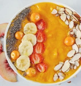 close up view of mango smoothie in a white bowl