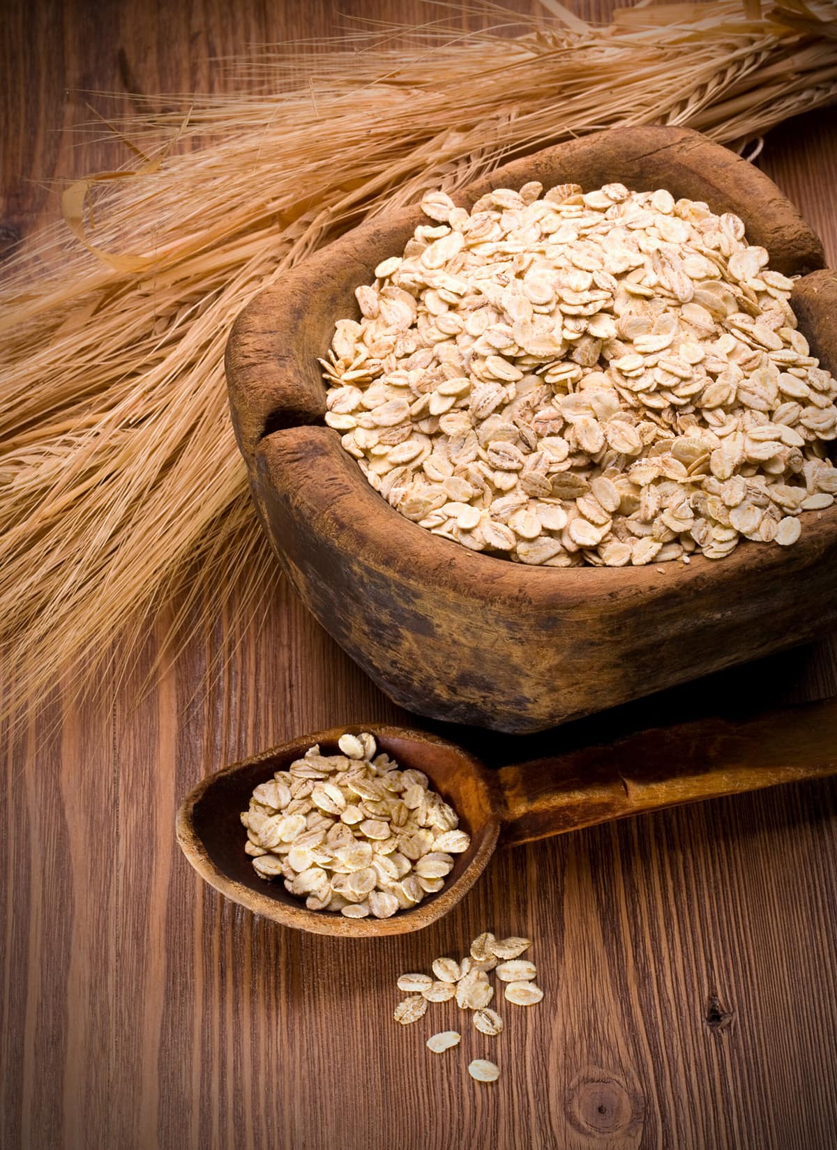 oatmeal in wooden bowl and wooden spoon