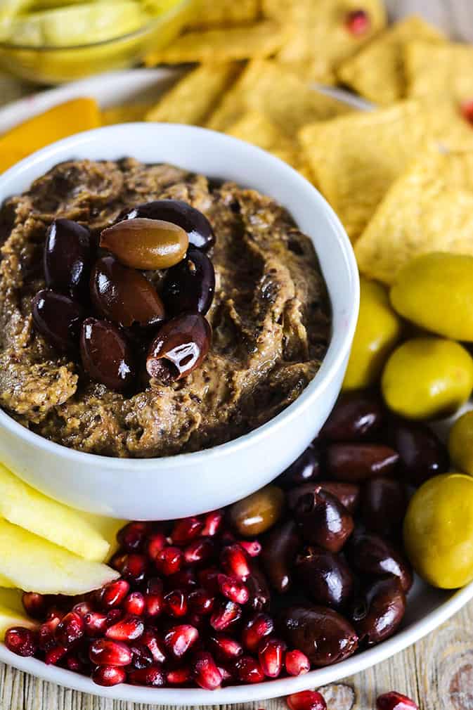 Vegan Olive Dip in white bowl surrounded by veggies
