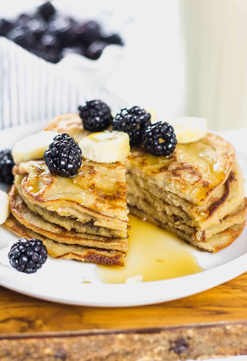 banana-oatmeal-pancakes-sliced on white plate on white background