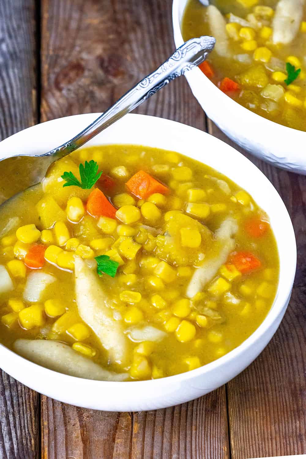 Trinidadian corn soup on white bowl on wooden background