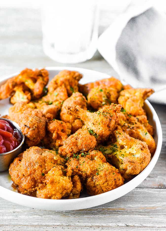 cauliflower nuggets on white plate on white background