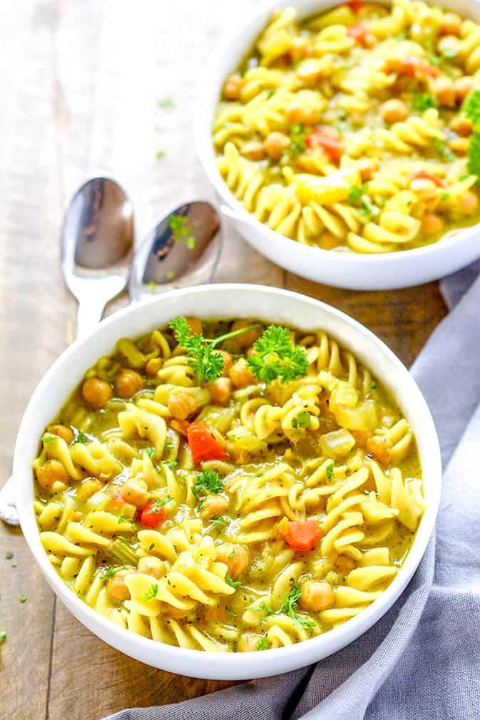 Chickpea noodle soup in two bowls on a white background