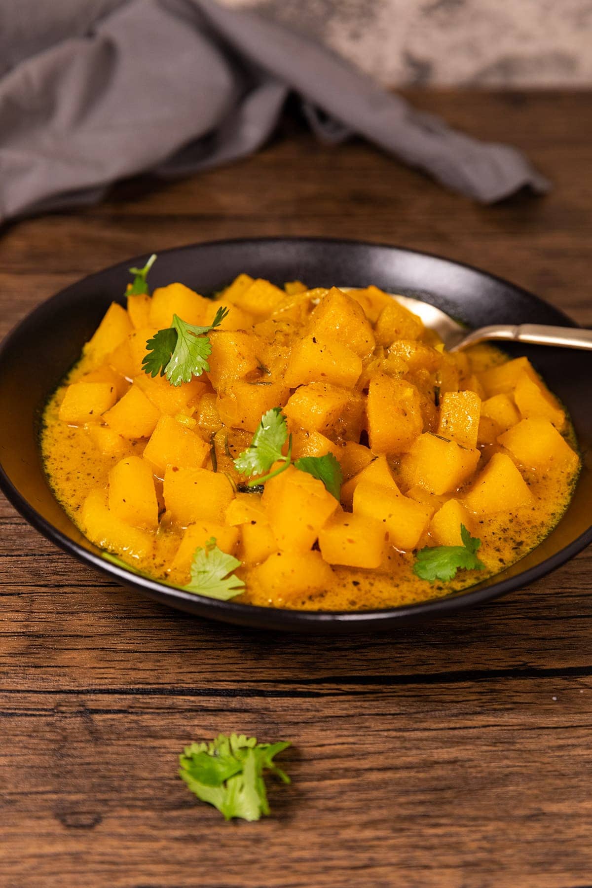 Kohlrabi Curry in aa black bowl wooden background