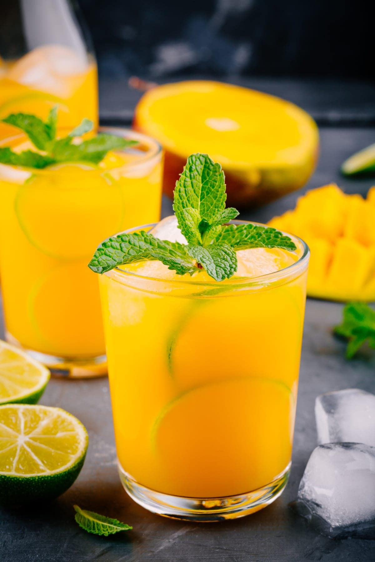 Mango lemonade in glass cup on grey background