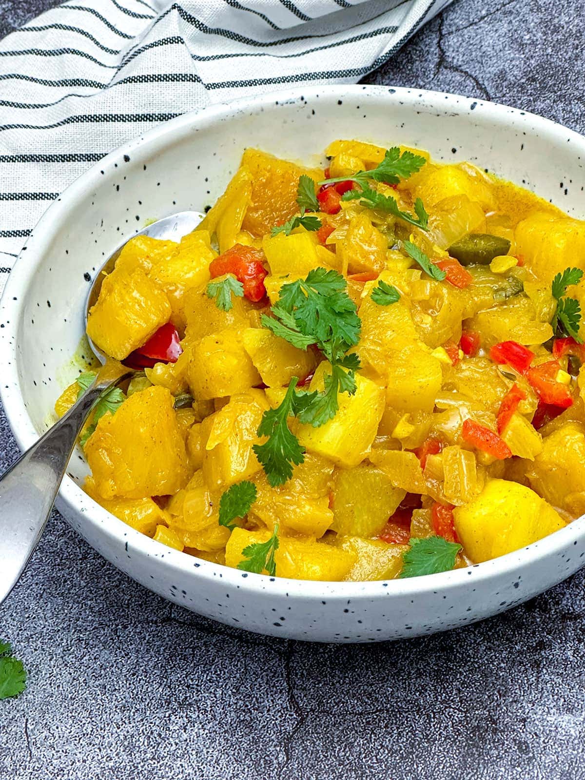 Pineapple Curry in a white bowl on grey background