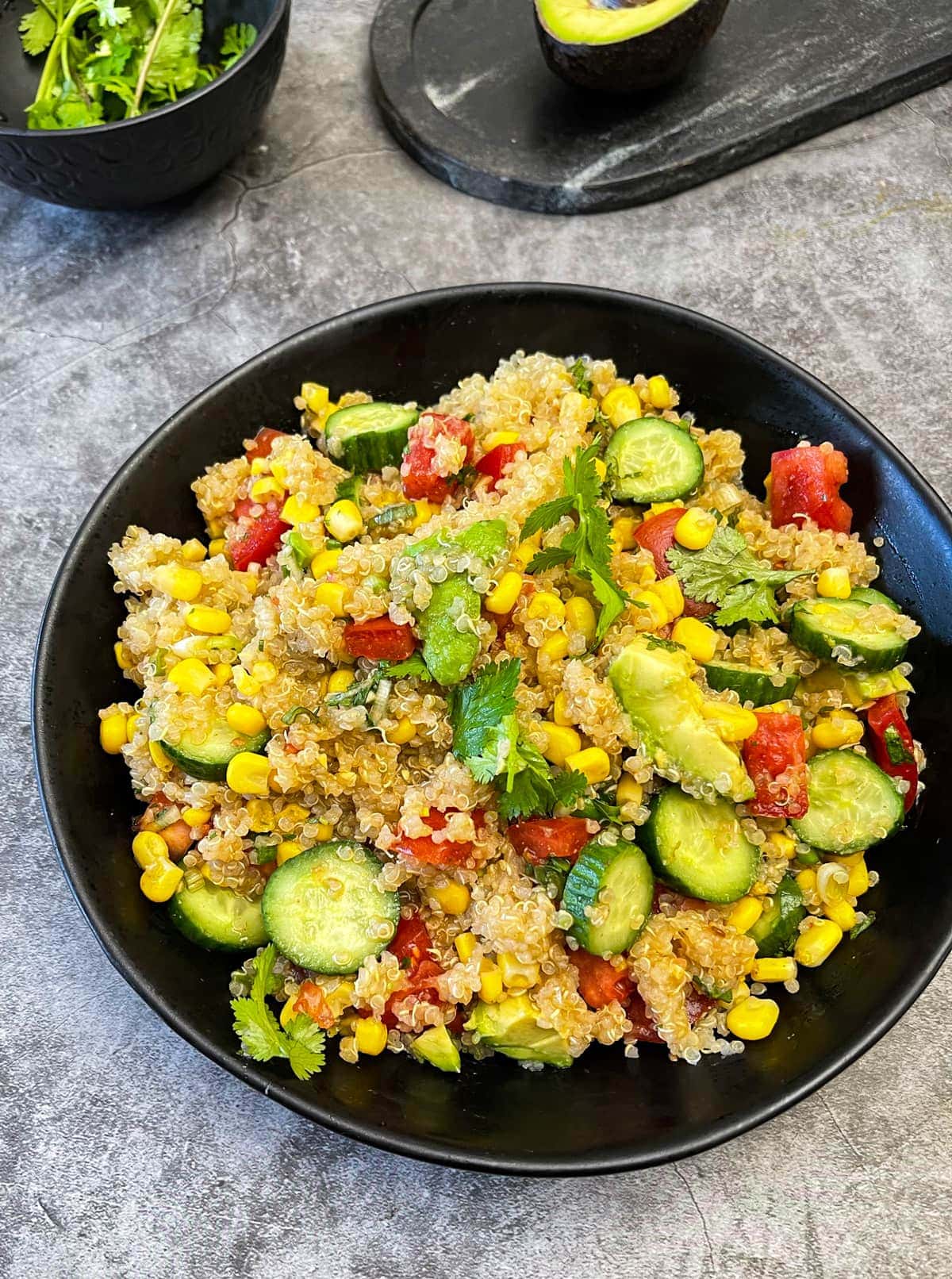 Quinoa Salad in a black bowl grey background