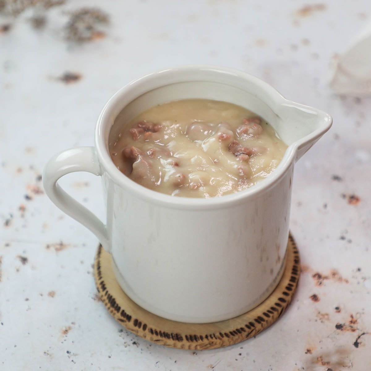 sausage gravy vegan on white cup on white background