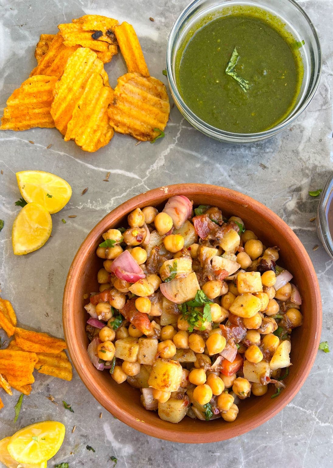 tamarind chickpea chaat on a clay bowl on grey background