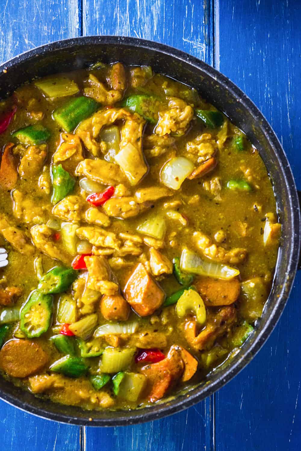 vegan gumbo recipe in a black skillet on blue background