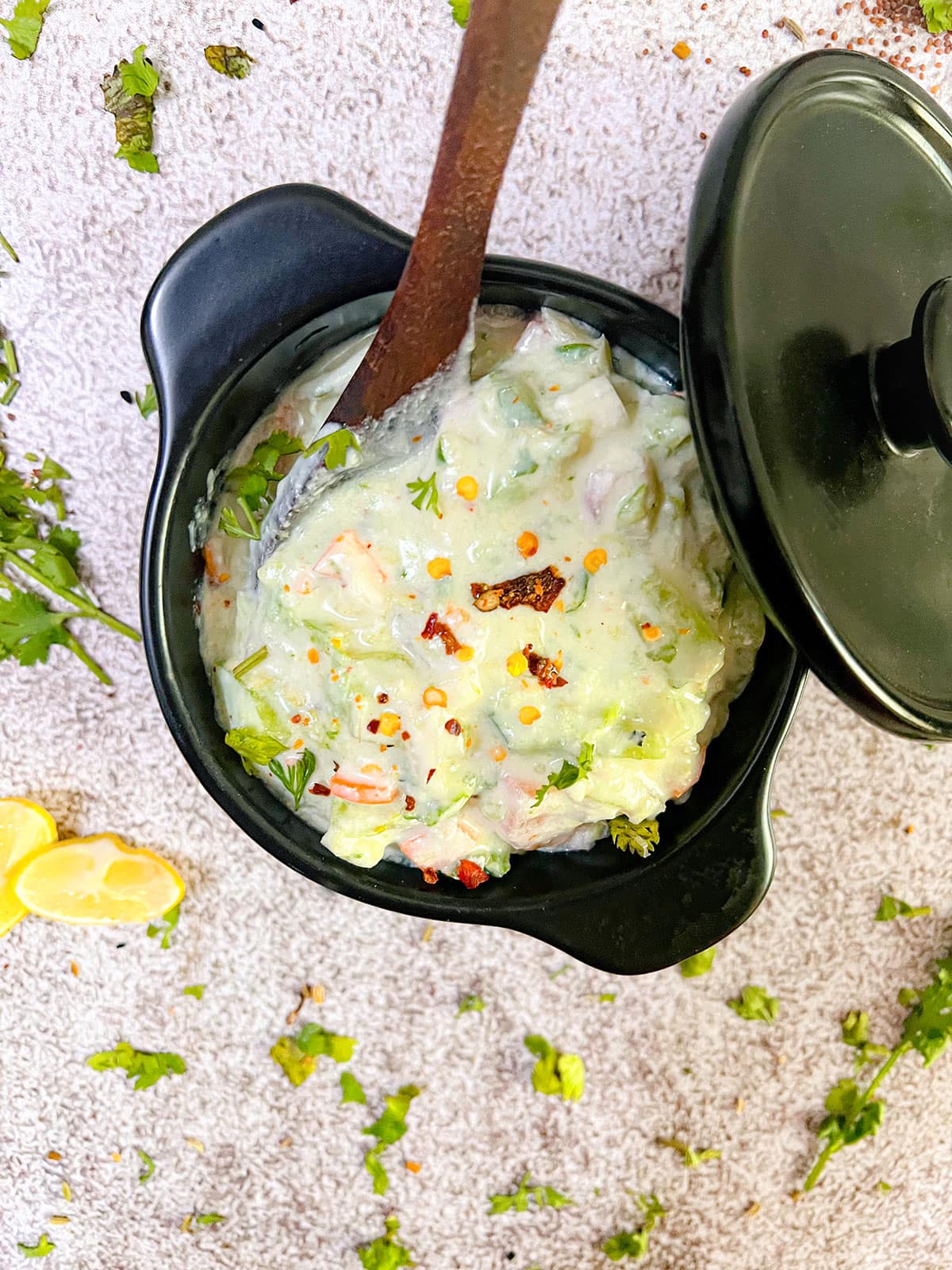 vegan veggie dip overlay photo in a black bowl with wooden spoon on grey background