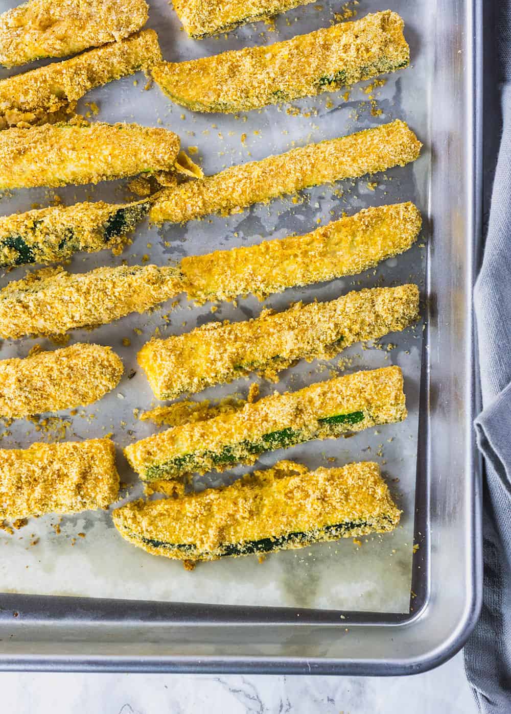 zucchini fries on glass bowl on white background