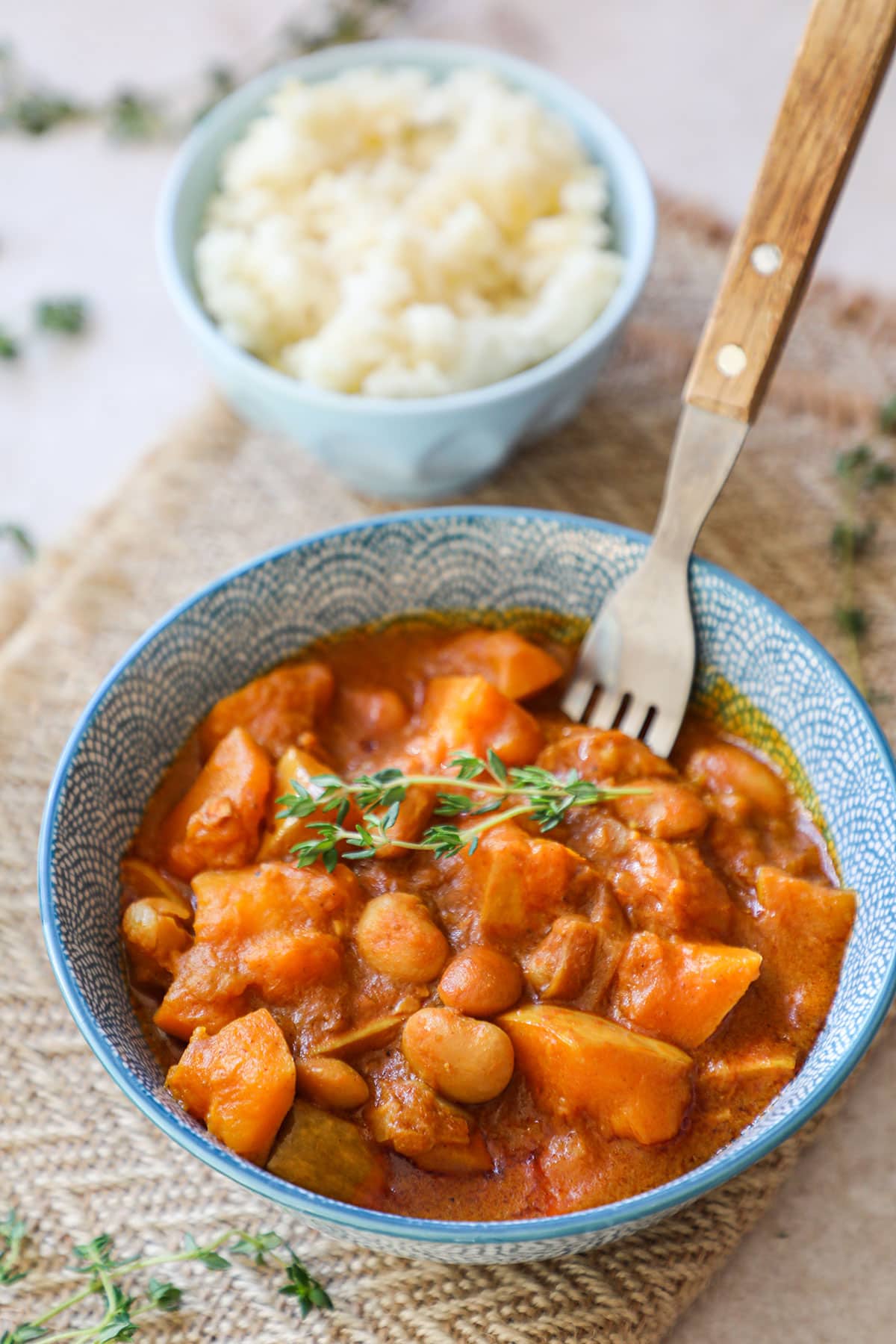 Jamaican pumpkin curry in a blue and white bowl on a burlap napkin