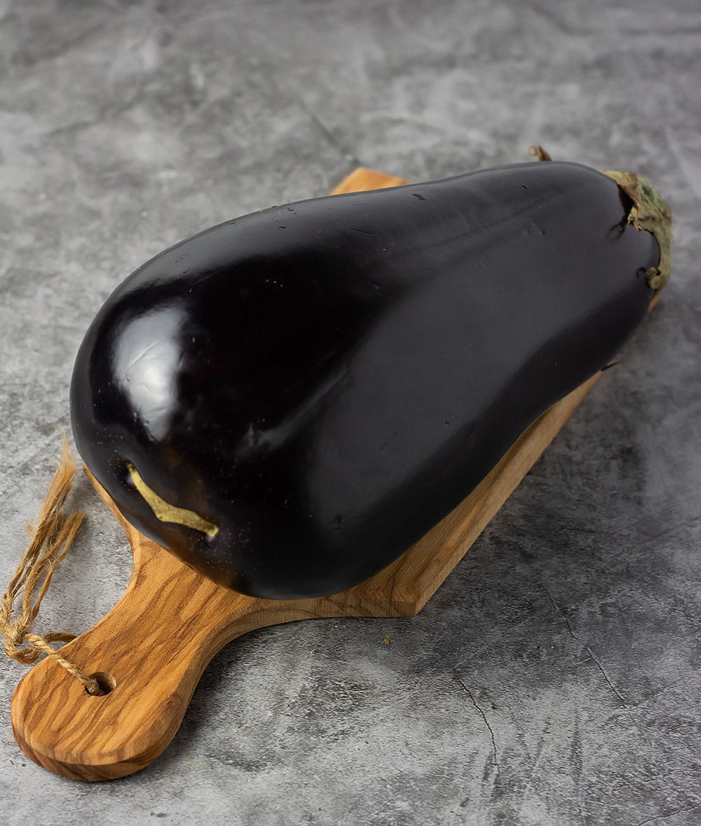 Eggplant for eggplant curry on a cutting board