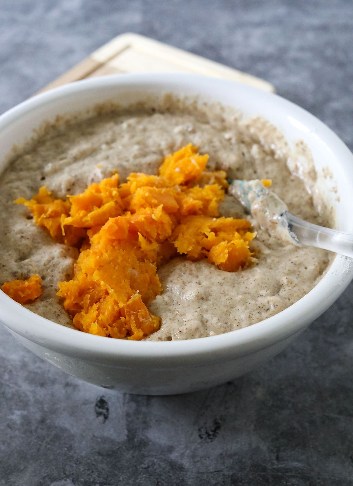 batter in a white bowl with butternut squash on top