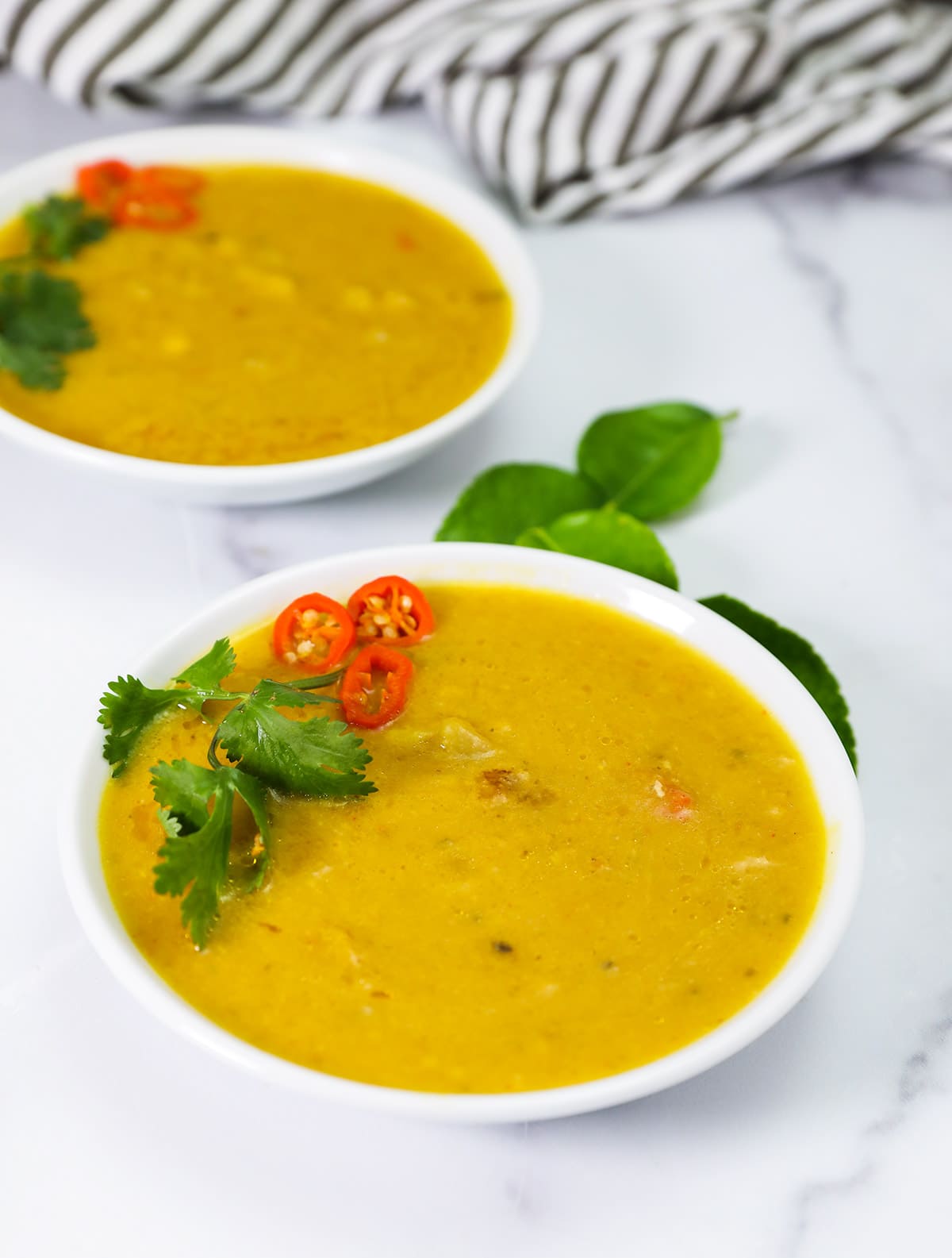 Close up thai pumpkin soup in two white bowls on white background