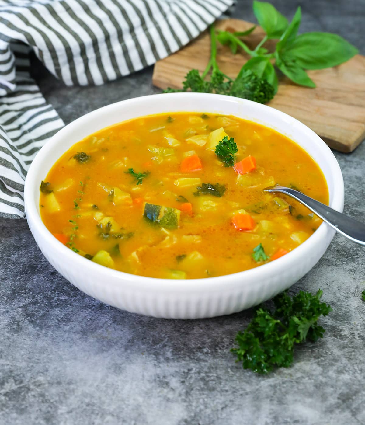 vegetable pumpkin soup in a white bowl on a grey background