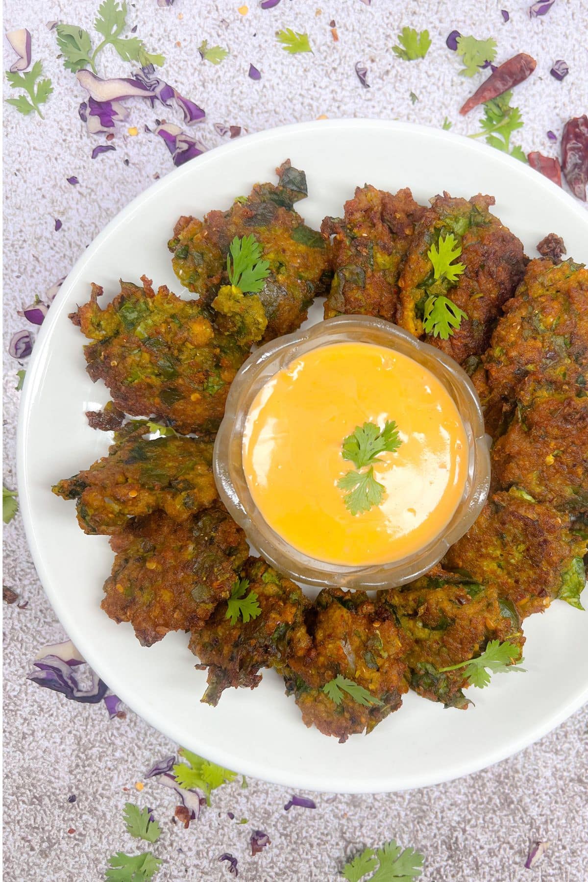 overlay vegan spinach yellow lentil bhajis recip on white plate on grey background