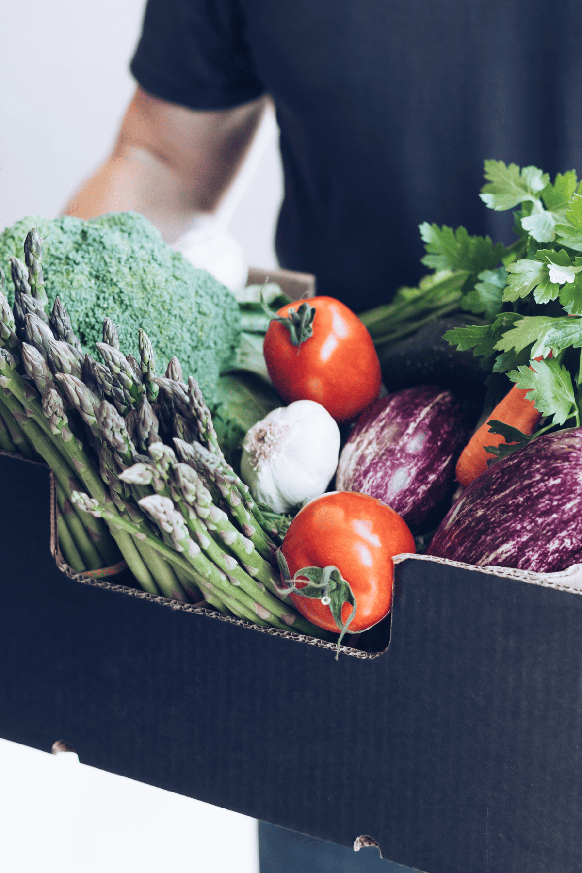 man holding a csa box with produce